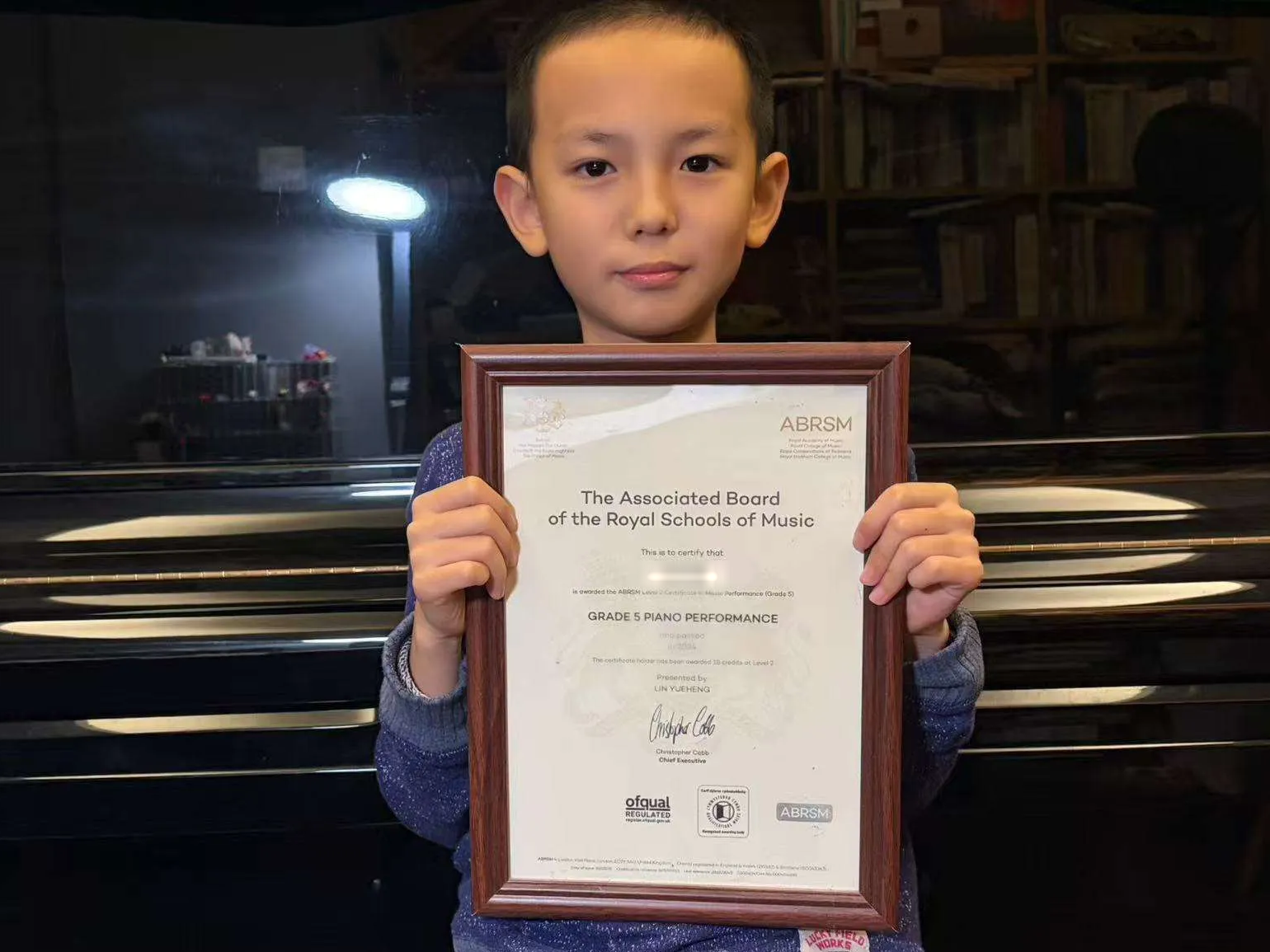 Piano student holding a music certificate